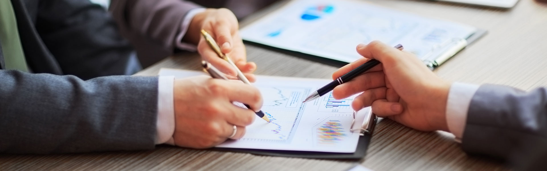 Three people point to a diagram with pens | Risk Assessment by NW Assekuranz