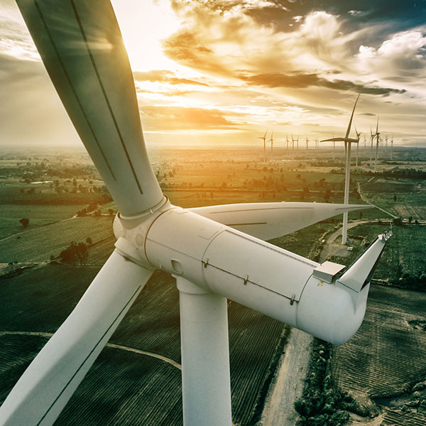 Front view of the hub and nacelle of a wind turbine, in the background the remaining wind turbines of the wind farm | Risk coverage for full maintenance for onshore wind turbines with NW Assekuranz