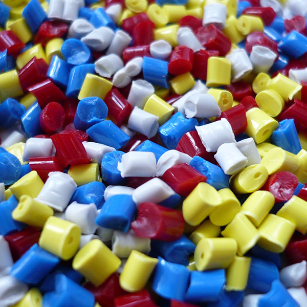 Plastic granules in blue, white, red and yellow | Risk management for the plastics industry with NW Assekuranz